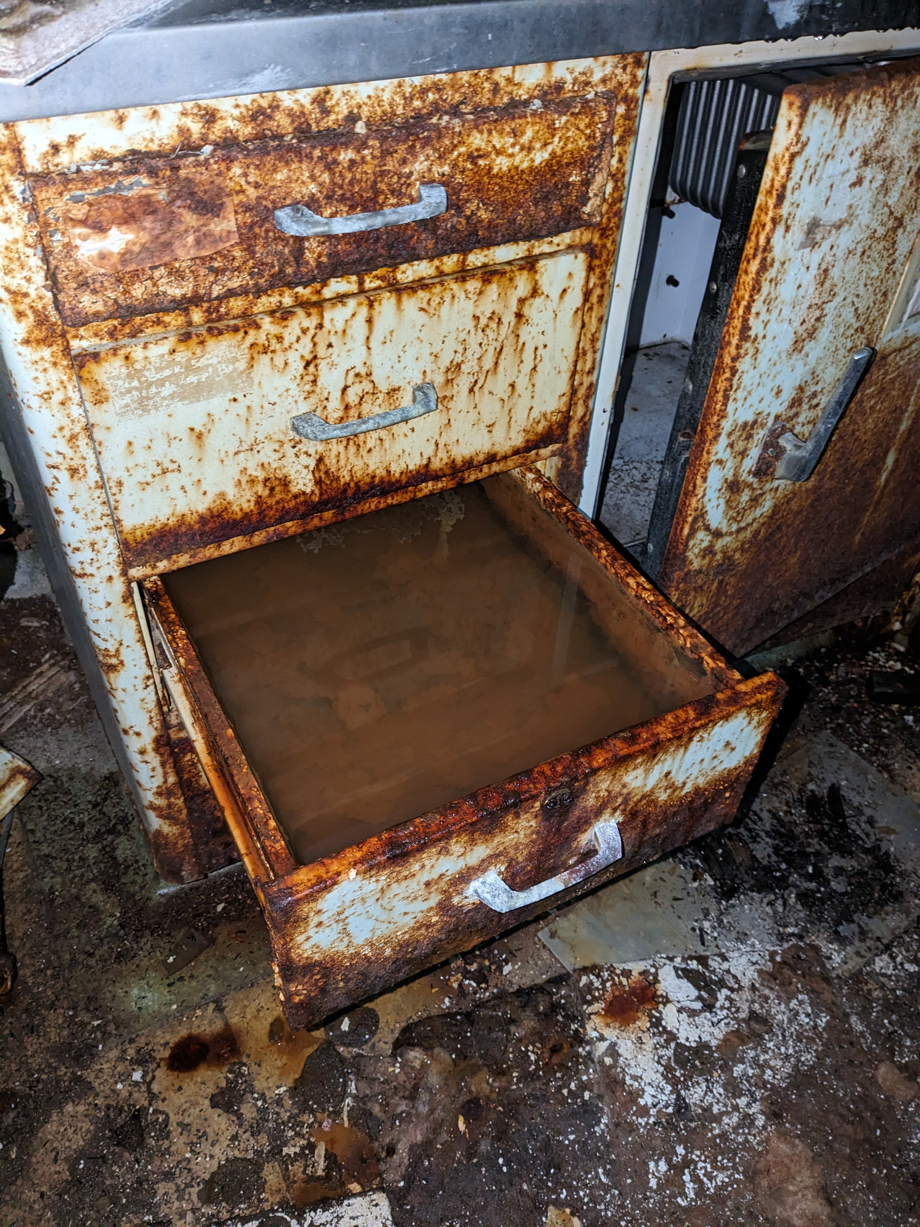 rusty filing cabinet with a drawer open and filled with water